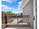 Beautiful outdoor balcony with black iron railings overlooking a lush landscaped yard at 7471 Gathering Loop, Reunion, FL 34747