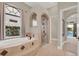 Elegant bathroom featuring a soaking tub under an arched window and a glass-enclosed shower at 7471 Gathering Loop, Reunion, FL 34747