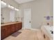 Bathroom featuring double vanities, a large mirror, and a soaking tub for a luxurious experience at 7471 Gathering Loop, Reunion, FL 34747