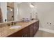 Bathroom featuring granite counters, double sinks, wooden cabinets and a glass door shower at 7471 Gathering Loop, Reunion, FL 34747