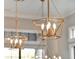 Close-up of modern gold chandeliers featuring geometric design with bright lights at 7471 Gathering Loop, Reunion, FL 34747