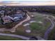 An aerial view of a meticulously manicured golf course surrounding a large, luxurious house with a private swimming pool at 7471 Gathering Loop, Reunion, FL 34747