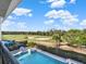 Scenic golf course view from the balcony overlooking the pool and lush greenery on a sunny day at 7471 Gathering Loop, Reunion, FL 34747