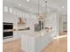 Modern kitchen featuring white cabinets, stainless steel appliances, a large island and pendant lighting at 7471 Gathering Loop, Reunion, FL 34747