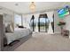 Bright main bedroom featuring balcony access, neutral decor, and a decorative chandelier at 7471 Gathering Loop, Reunion, FL 34747