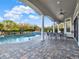 Covered patio with a dining table, ceiling fan, and view of the pool and well-manicured backyard at 7471 Gathering Loop, Reunion, FL 34747