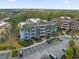 Aerial view of condo complex with mature landscaping, lush trees, and a parking lot at 7652 Whisper Way # 401, Reunion, FL 34747