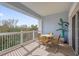 Relax on this spacious balcony with comfortable seating and a serene view of the surrounding trees at 7652 Whisper Way # 401, Reunion, FL 34747