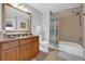 Bathroom featuring tub with shower, vanity with granite countertop and framed mirror at 7652 Whisper Way # 401, Reunion, FL 34747