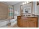 Bathroom featuring tub with shower, vanity with granite countertop and framed mirror at 7652 Whisper Way # 401, Reunion, FL 34747