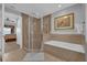 Bright bathroom featuring glass enclosed shower, soaking tub, and neutral color palette at 7652 Whisper Way # 401, Reunion, FL 34747