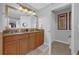 Well-lit bathroom with double vanity, granite countertop, and framed mirror at 7652 Whisper Way # 401, Reunion, FL 34747