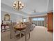 Elegant dining area with chandelier lighting and seating for four near sliding glass doors to the outdoor patio at 7652 Whisper Way # 401, Reunion, FL 34747