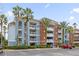 Beautiful condo exterior with tropical landscaping, balconies, and parking at 7652 Whisper Way # 401, Reunion, FL 34747