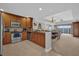 Well-equipped kitchen featuring stainless steel appliances and wood cabinetry and view to the dining area at 7652 Whisper Way # 401, Reunion, FL 34747