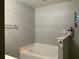 Bathroom with a large soaking tub, gray walls, and a small window for natural light at 856 Jarnac Dr, Kissimmee, FL 34759