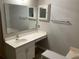 Bathroom featuring a vanity with sink, large mirror, wall cabinet, and white countertop at 856 Jarnac Dr, Kissimmee, FL 34759