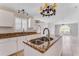 Bright kitchen with an island, granite countertops, white cabinets and stainless steel sink at 856 Jarnac Dr, Kissimmee, FL 34759