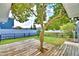 Backyard featuring a wood deck built around a tree and black metal fencing, ideal for outdoor relaxation at 105 Shaddock Dr, Auburndale, FL 33823