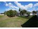 Spacious fenced backyard featuring a well-maintained lawn and screened-in pool area at 105 Shaddock Dr, Auburndale, FL 33823