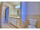 Neutral-toned bathroom features a tile floor and a white toilet, sink and vanity at 105 Shaddock Dr, Auburndale, FL 33823