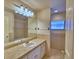 Bathroom features tiled shower and sink with white cabinetry, neutral color palette, and lots of natural light at 105 Shaddock Dr, Auburndale, FL 33823