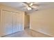 Bedroom featuring neutral walls, carpeted floor, ceiling fan, a window, and a double closet at 105 Shaddock Dr, Auburndale, FL 33823