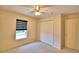 Bedroom featuring neutral walls, carpeted floor, ceiling fan, a window, and a double closet at 105 Shaddock Dr, Auburndale, FL 33823