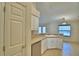 Well-lit kitchen featuring a breakfast bar with sink, white cabinetry, stainless dishwasher, and pantry access at 105 Shaddock Dr, Auburndale, FL 33823