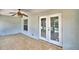 Enclosed porch featuring tile flooring and a ceiling fan with double doors leading to the pool area at 105 Shaddock Dr, Auburndale, FL 33823