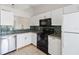 Well-lit kitchen with white cabinets, concrete countertops and black appliances at 11 Silver Falls Cir, Kissimmee, FL 34743