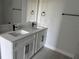 Bright bathroom featuring a double vanity with white cabinets, quartz countertop, and modern black fixtures at 113 Dogwood Drive Circle, Ocala, FL 34472