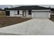 A modern, single-story home shows off it's fresh concrete driveway and minimalist white with black trim exterior at 113 Dogwood Drive Circle, Ocala, FL 34472