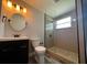 Bathroom showcasing modern fixtures, shower, and a round mirror above the sink at 1225 Nemeth St, Auburndale, FL 33823