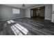 Sunlit living room featuring wood-look floors and a view into the hallway at 1225 Nemeth St, Auburndale, FL 33823