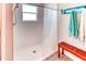 Clean shower room with white tiled walls, matching shower curtain and wooden bench at 125 Inconnu Ct, Poinciana, FL 34759