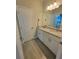 Bright bathroom featuring granite countertops, white cabinets, and a double vanity at 125 Inconnu Ct, Poinciana, FL 34759