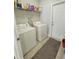 Functional laundry room with washer, dryer, and ample shelving at 125 Inconnu Ct, Poinciana, FL 34759