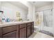 Well-lit bathroom featuring double sinks, a spacious vanity, and a shower-tub combination with stylish curtain at 1368 Berry Ln, Davenport, FL 33837