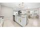 Spacious kitchen island with a stainless steel dishwasher and sink, and a view into the dining and living areas at 1368 Berry Ln, Davenport, FL 33837