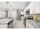 Modern kitchen featuring white cabinets, stainless steel appliances, granite countertops, and a central island at 1368 Berry Ln, Davenport, FL 33837