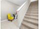 Carpeted staircase with white railing and a decorative table with a yellow chair at 1368 Berry Ln, Davenport, FL 33837