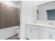Bright bathroom featuring a double vanity, large mirror, tub, and stylish tiled shower at 139 Aces High Ln, Davenport, FL 33896