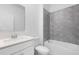 Modern bathroom features a gray tiled shower and bathtub combination, with white vanity at 139 Aces High Ln, Davenport, FL 33896