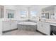 Bright bathroom with dual sinks, a corner tub, and large mirrors at 139 Aces High Ln, Davenport, FL 33896