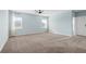 A light and airy bedroom featuring neutral carpet, light blue walls and two windows at 139 Aces High Ln, Davenport, FL 33896