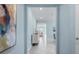 Bright hallway with gray tile floors and artwork on the light-blue walls at 139 Aces High Ln, Davenport, FL 33896