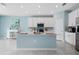 Bright kitchen features white cabinets, stainless steel appliances, and central island with counter seating at 139 Aces High Ln, Davenport, FL 33896