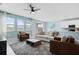 Bright living room with a ceiling fan, tile flooring, and lots of natural light from the windows at 139 Aces High Ln, Davenport, FL 33896