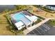 Aerial view of community pool with lounge chairs, tables, playground, and lake at 139 Aces High Ln, Davenport, FL 33896